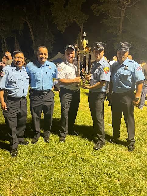 Members of the Mastic Fire Department proudly hold their trophy for “Most Members in a Line,” 2022.